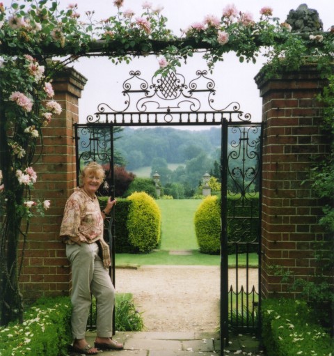 Dr. Barbara Sommerville at the pretty wrought Iron gate of the Rose Garden at Polsden Lacy, Surrey. Beyond is the stunning North Chalk Down scenery.