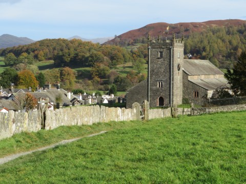 Slate slab wall with the church and village of Hawkshead and a back drop of hills, Cumbria, UK