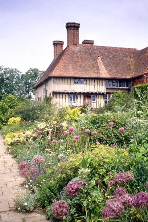 The wide herbaceous border at Great Dixter in Kent with a 16C timbered Court house behind extending the 15C house.