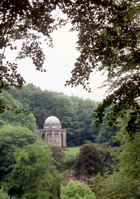 the temple of Appollo on its hill screened by mature trees.