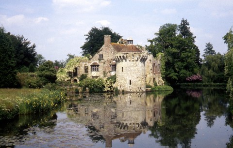 The remaining bastion of the 14C castle with the ruined 17C one behind and the wide moat in front.